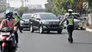 Polisi memberhentikan kendaraan saat hari pertama pemberlakuan perluasan sistem ganjil genap di Jalan Salemba Raya, Jakarta, Senin (9/9/2019). Polisi memberlakukan sanksi tilang terhadap pengendara yang melanggar aturan sistem ganjil genap. (merdeka.com/Iqbal Nugroho)