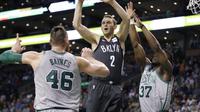 Guard, Brooklyn Nets, Nik Stauskas (tengah) mencoba melepaskan diri dari dua hadangan pemain Boston Celtics, Aron Baynes (46) dan Semi Ojeleye (kanan) di Boston dalam lanjutan NBA, Kamis (12 April 2018) WIB. (AP Photo/Elise Amendola)