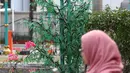 Seorang pegawai melintas di samping pohon imitasi yang terpasang di halaman Balai Kota DKI Jakarta, Senin (4/6). (Liputan6.com/Arya Manggala)