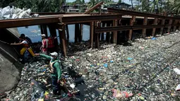 Para pekerja mengumpulkan sampah dari Sungai Marilao di Bulacan, sebelah utara Manila, Filipina, 18 Maret 2017. Air di sungai ini memiliki oksigen terlarut yang sangat rendah sehingga membuat ikan dan spesies lain sulit hidup di dalamnya. (Noel CELIS/AFP)