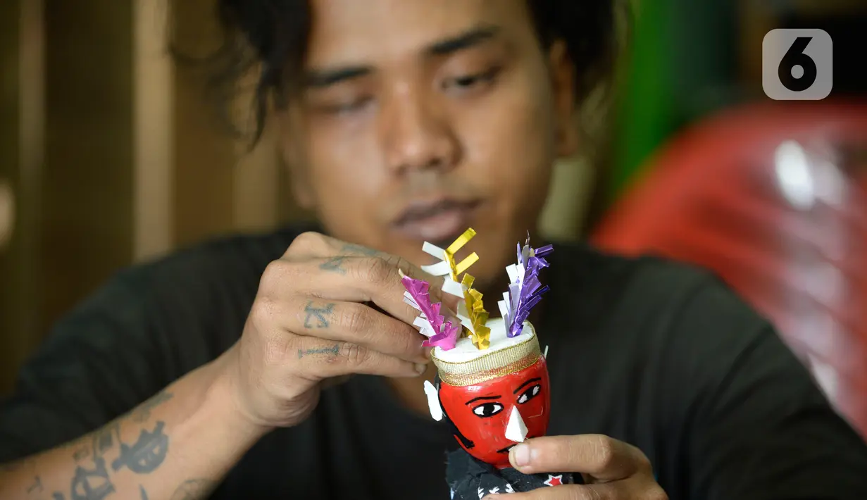 Pengrajin sedang menyelesaikan ondel-ondel hiasan yang terbuat dari limbah plastik botol di Kampung Sawah Lama, Ciputat, Tangerang Selatan, banten, Jumat (4/9/2020). Dalam satu hari perajin bisa menyelesaikan 30 biji kerajinan ondel-ondel budaya khas Betawi. (merdeka.com/Dwi Narwoko)