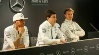 Bos Mercedes GP, Toto Wolff (tengah), mengaku tak segan untuk memecat Lewis Hamilton (kiri) atau Nico Rosberg jika persaingan keduanya memberikan pengaruh buruk bagi tim. (Crash)