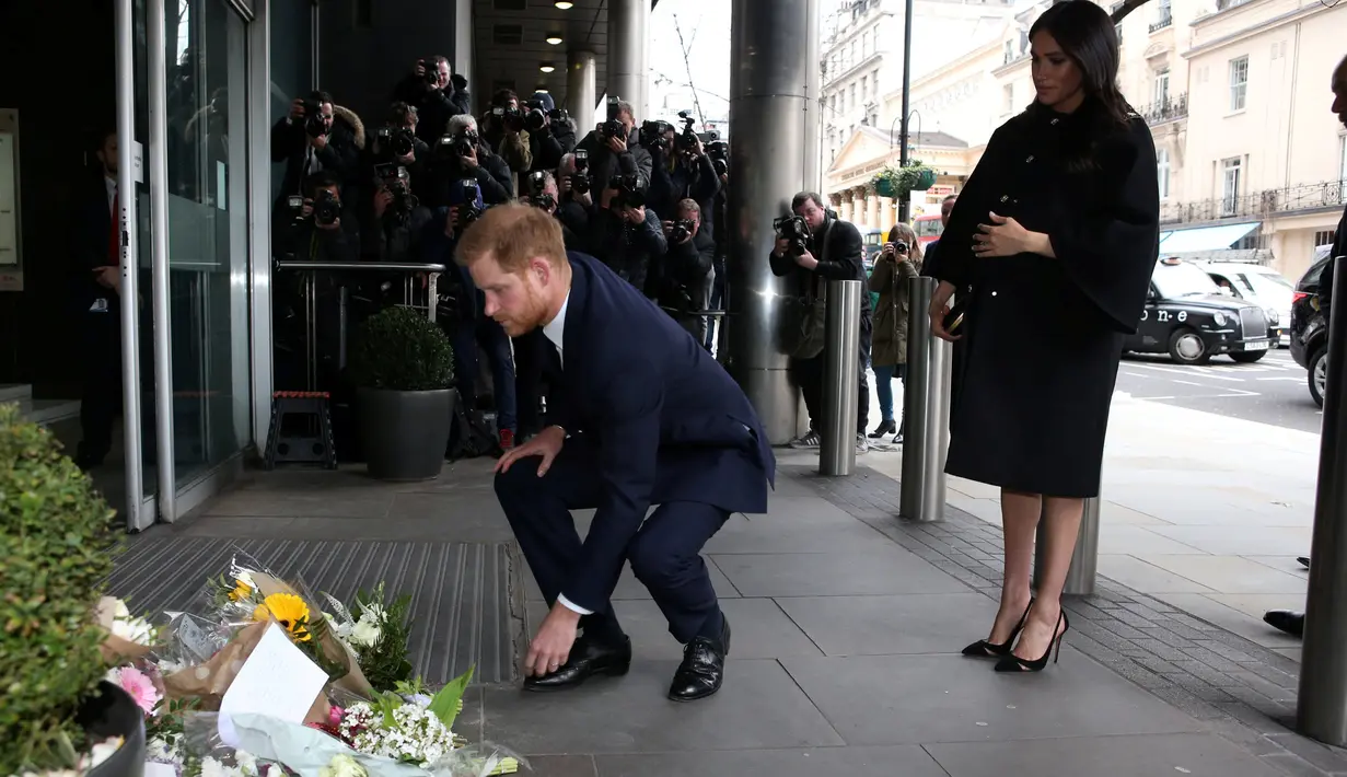 Pangeran Harry dan Meghan Markle meletakkan karangan bunga sebagai penghormatan kepada para korban serangan teror di Christchurch saat mengunjungi Komisi Tinggi Selandia Baru di London, Selasa (19/3). (Ian Vogler/Pool via REUTERS)