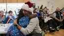 Mantan Presiden AS, Barack Obama memeluk seorang pasien anak di Children's National Medical Center , Washington, Rabu (19/12). Kedatangan Obama yang menyerupai sinterklas itu untuk membagikan hadiah natal kepada anak-anak di sana. (Chuck Kennedy / AFP)