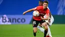 Pemain depan Mallorca, Matthew Hoppe (depan) bersaing dengan bek Real Madrid, David Alaba pada jornada keenam La Liga Spanyol di Santiago Bernabeu, Kamis (23/9/2021) dini hari WIB. Real Madrid berpesta gol usai melibas Real Mallorca 6-1. (GABRIEL BOUYS / AFP)