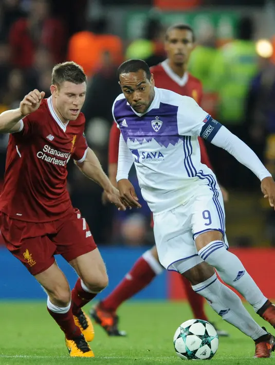 Pemain Liverpool, James Milner berebut bola dengan pemain Maribor, Marcos Tavares pada laga lanjutan Grup E Liga Champions di Anfield, Kamis (2/11). Pasukan The Reds mengunci kemenangan dengan skor 3-0 dalam laga tersebut. (AP/Rui Vieira)