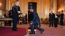 Mantan pesepak bola, David Beckham (kanan) dianugerahi gelar Ksatria oleh Raja Inggris, Charles III dalam upacara penobatan di Kastil Windsor, Berkshire, Inggris, Selasa (04/11/2025) waktu setempat. (AP Photo/PA/Jonathan Brady)