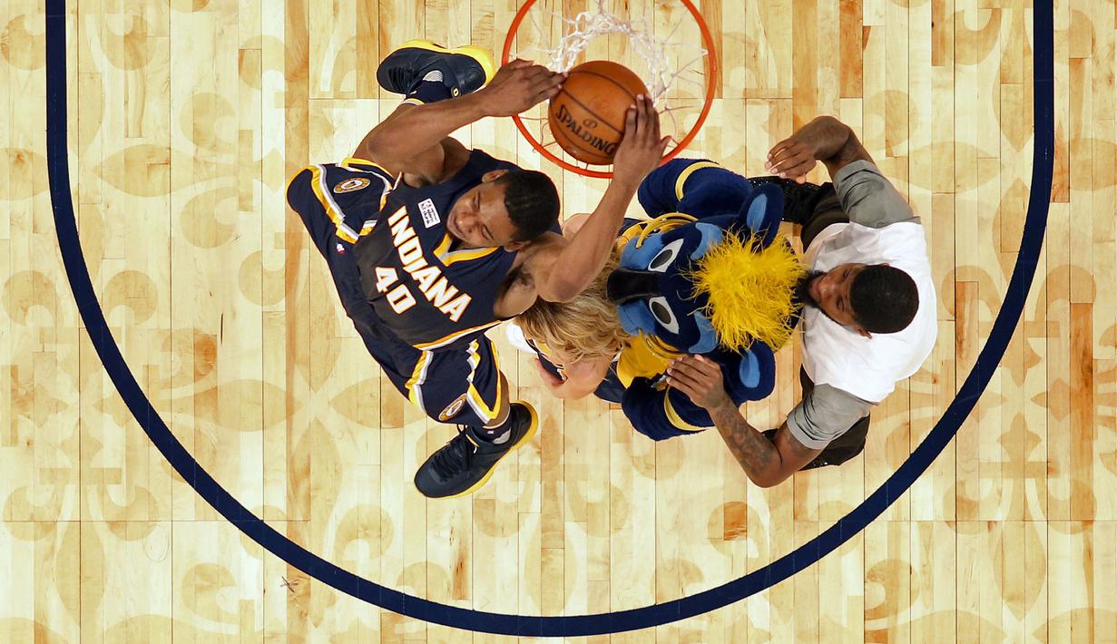 Ekspresi pemain Indiana Pacers, Glenn Robinson III saat melakukan slam dunk melewati rekannya Paul George, Maskot dan   seorang cheerleader pada ajang NBA All-Star Saturday Night di New Orleans, (18/2/2017).  (AP/Gerald Herbert)