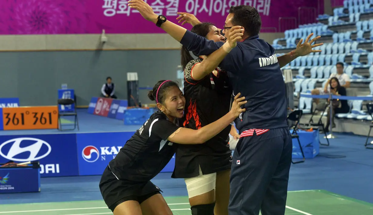 Nitya Krishinda (tengah) dan Gresya Polii (kiri) memeluk pelatih mereka Eng Hian (kanan) usai memenangkan final perorangan Ganda Putri Asian Games ke-17 di Gyeyang Gymnasium, Incheon, Korsel, Sabtu (27/9). (ANTARA FOTO/SAPTONO)