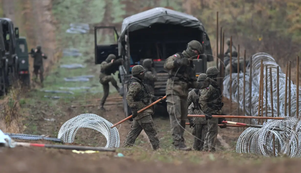 Tentara Polandia mulai memasang penghalang kawat berduri di sepanjang perbatasan Polandia dengan eksklave Rusia, Kaliningrad di Wisztyniec, Polandia, Rabu (2/11/2022). Penghalang itu akan dibuat dari tiga baris kawat berduri dengan tinggi 2,5 meter dan lebar tiga meter yang dibangun dengan sistem pemantauan elektronik dan kamera.  (AP Photo/Michal Kosc)