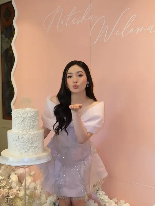 Bagian bahu dihiasi dengan aksen bow besar yang menambah kesan dramatis dan mewah, sementara potongan A-line pada gaun memberikan tampilan anggun dan youthful.  [@natashawilona12].