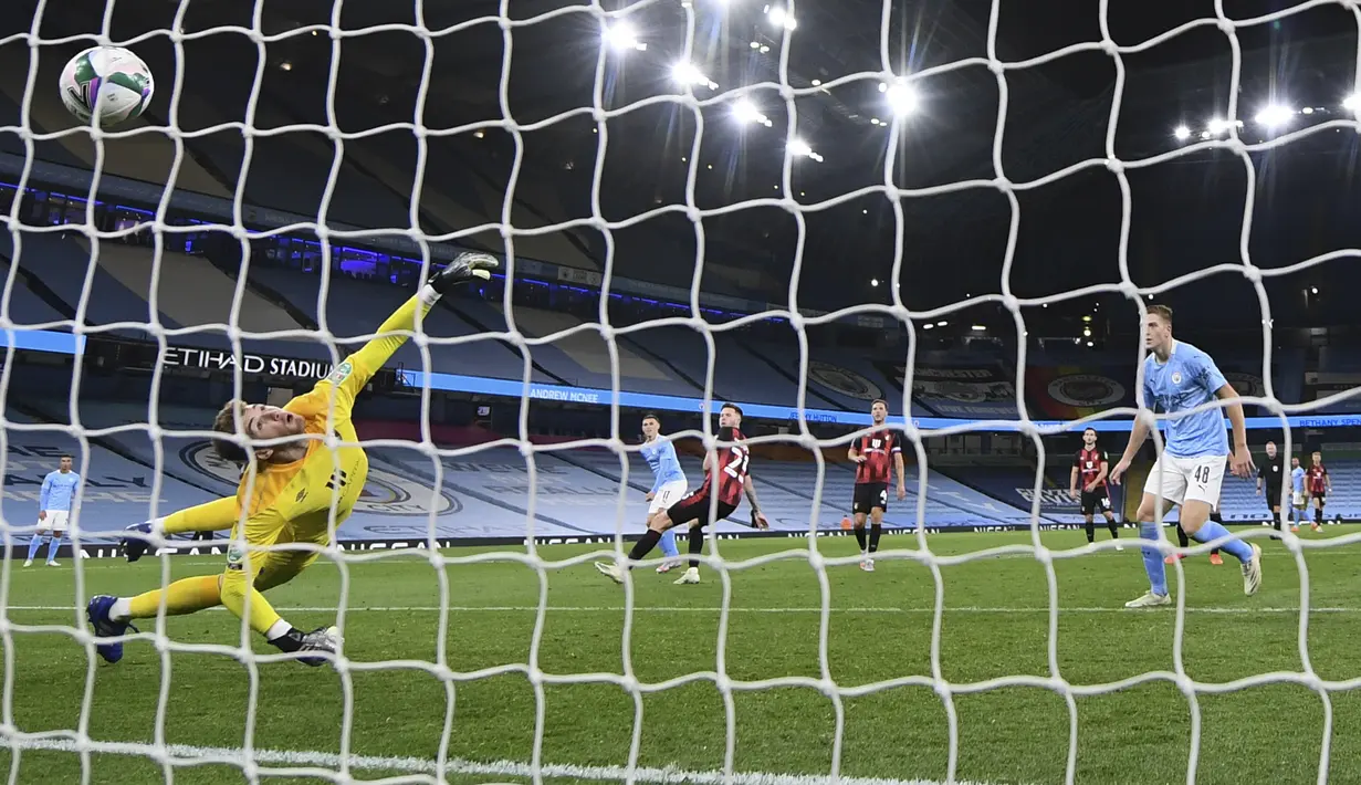 Penjaga gawang Bournemouth, Mark Travers gagal menghentikan tendangan gelandang Manchester City, Phil Foden pada pertandingan putaran ketiga Piala Liga Inggris di City of Manchester Stadium di Manchester, Inggris, Kamis (24/9/2020). City menang tipis atas Bournemouth 2-1. (Laurence Griffiths/Pool vi