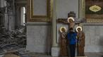 Seorang anak laki-laki mencium patung Yesus saat membantu membersihkan Katedral Transfigurasi Odesa setelah gereja rusak berat akibat serangan rudal Rusia di Odesa, Ukraina, Minggu, 23 Juli 2023. (AP Photo/Jae C. Hong)