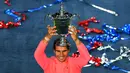 Petenis peringkat satu dunia, Rafael Nadal mengangkat trofi AS Terbuka 2017 setelah mengalahkan petenis Afrika Selatan, Kevin Anderson di New York, Minggu (10/9).Nadal mengalahkan Kevin Anderson dengan skor 3-0. (AFP PHOTO/TIMOTHY A. CLARY)