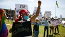 Demonstran membawa poster tuntutan saat memprotes Presiden Brasil Jair Bolsonaro dan penanganan virus corona di Brasilia, Minggu (31/1/2021). Covid-19 merenggut lebih dari 223.000 nyawa menjadikan Brasil sebagai negara dengan jumlah kematian terbanyak kedua di dunia. (Sergio LIMA/AFP)