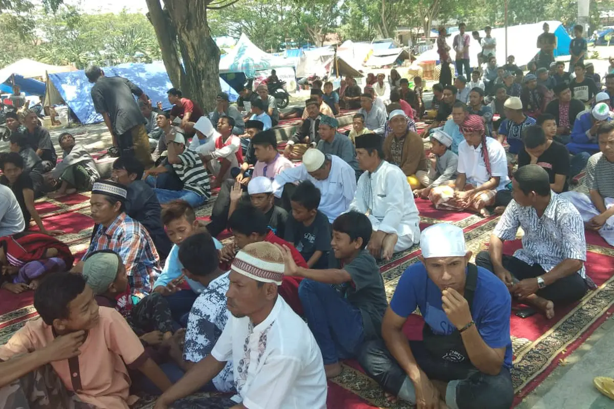 Ratusan warga Palu, Sulawesi Tengah yang menjadi korban gempa dan tsunami melaksanakan salat Jumat