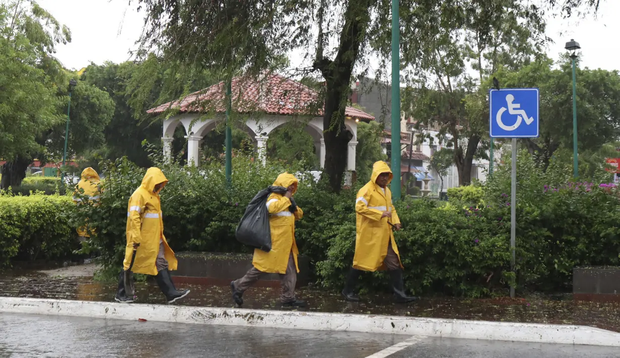 Petugas kotamadya memindahkan cabang sebelum Badai Agatha mendarat di Huatulco, Negara Bagian Oaxaca, Meksiko pada Senin (30/5/2022). Badai Agatha, yang pertama musim ini, mendarat pada hari Senin di dekat serangkaian resor pantai di Pantai Pasifik Meksiko, di mana penduduk dan turis bersembunyi di tempat perlindungan badai. (Gil OBED / AFP)