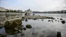 Orang-orang mengambil foto di ujung selatan Pulau Margaret, yang dapat dilihat karena rendahnya permukaan air Sungai Danube. di Budapest, Hungaria (9/8/2022). Ketinggian air Sungai Danube turun satu setengah meter dalam tiga minggu di dekat Budapest, sementara prakiraan hidrologi menunjukkan bahwa tidak ada penambahan curah hujan yang diharapkan untuk saat ini. (AP Photo/Anna Szilagyi)