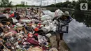 Warga membawa sampah sisa banjir yang dikumpulkan dari sepanjang Kali Cengkareng, Jakarta Barat, Kamis (9/1/2020). Tumpukan sampah di sepanjang bantaran kali dan rumah-rumah warga terlihat setelah banjir yang melanda sejumlah kawasan Jakarta mulai surut. (Liputan6.com/Johan Tallo)