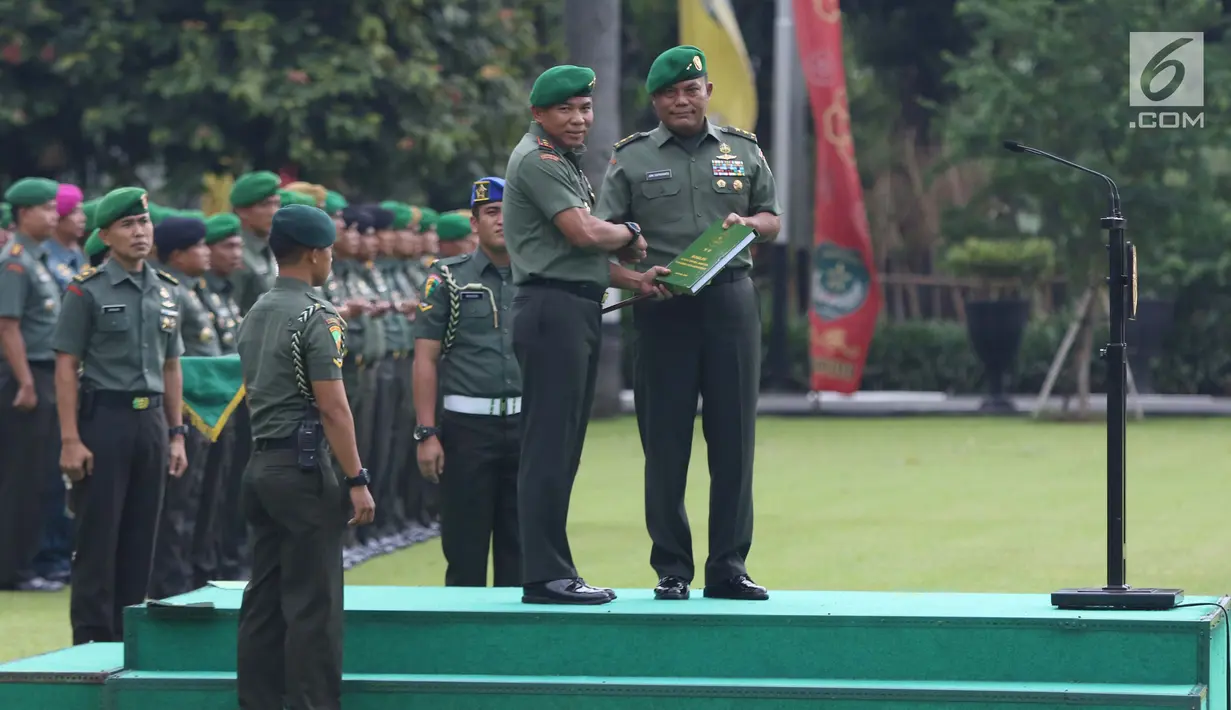 Mayjen TNI Joni Supriyanto (kanan) menyerahkan nota jabatan kepada Pangdam Jaya/Jayakarta yang baru, Mayjen TNI Eko Margiyono saat Apel Bersama Sertijab Pangdam Jaya/Jayakarta di Makodam Jaya, Jakarta, Kamis (31/1). (Liputan6.com/Helmi Fithriansyah)