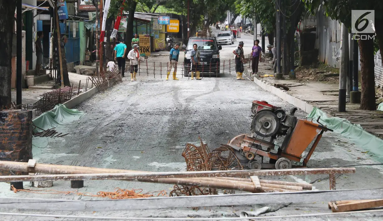 Pekerja menyelesaikan pembetonan Jalan Pejaten Raya di Jakarta Selatan (22/11). Proyek pembetonan dan peninggian badan jalan ini guna mengantisipasi banjir yang kerap terjadi di kawasan tersebut. (Liputan6.com/Immanuel Antonius)