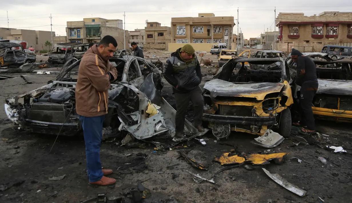 Sejumlah orang melihat-lihat di lokasi terjadinya ledakan bom mobil di permukiman al-Bayaa, Irak, Kamis (16/2). Pihak keamanan dan sumber medis mengatakan sedikitnya 48 orang tewas dan melukai 55. (AP Photo/ Karim Kadim) 