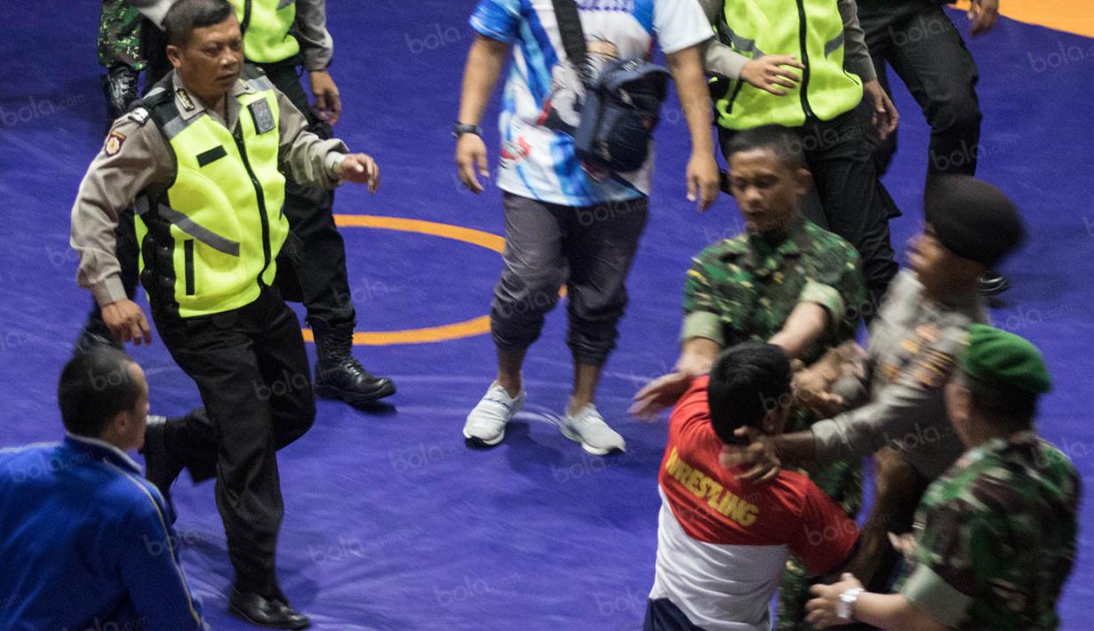 Melihat sang pelatih diamankan, Agus Setia langsung melakukan tindak penyerangan kepada pihak keamanan yang sedang berusaha melerai. (Bola.com/Vitalis Yogi Trisna)