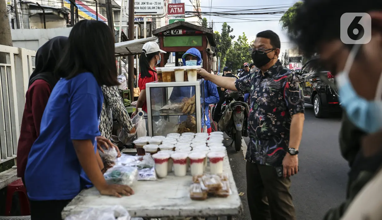 Pedagang menu berbuka puasa atau takjil melayani pembeli jelang waktu berbuka puasa di kawasan Radio Dalam, Jakarta Selatan, Senin (4/4/2022). Pedagang musiman yang menjual aneka takjil memanfaatkan momen bulan suci Ramadhan 1443 H. (Liputan6.com/Johan Tallo)