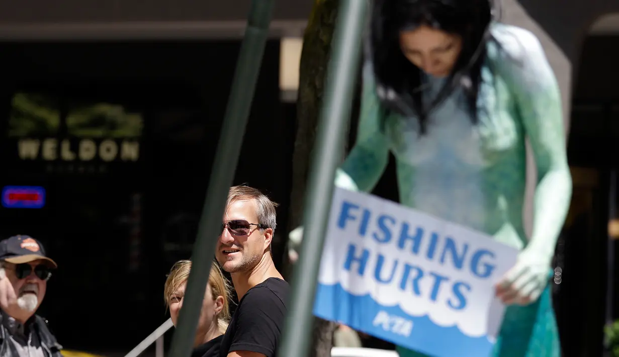Aksi menolak penangkapan ikan di Seattle, AS, Senin (5/6). Victoria Lemeow dikait selama satu jam sebagai bentuk empati kepada ikan saat mereka ditangkap untuk dikonsumsi manusia. (AP Photo / Elaine Thompson)