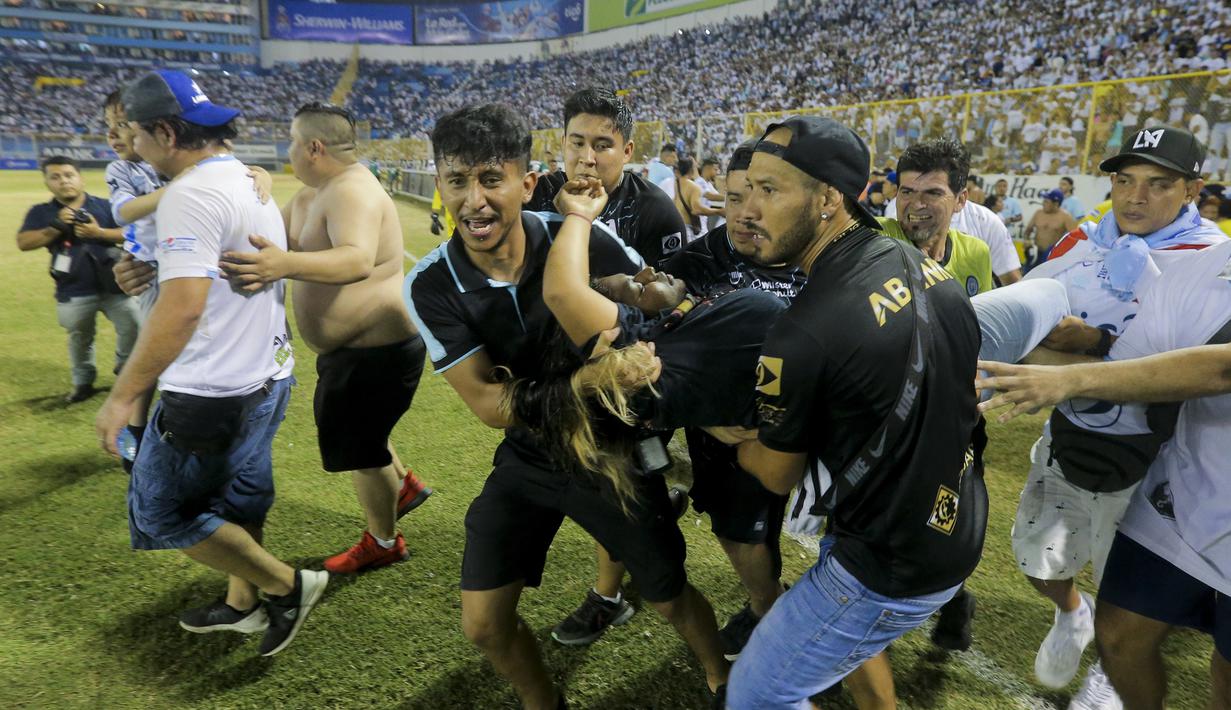 Tragedi sepak bola yang melibatkan suporter kembali terjadi. Kali ini 12 orang dilaporkan meninggal dunia dalam sebuah insiden tragis di Stadion Monumental, Cuscatlan, San Salvador, El Salvador, Sabtu (21/5/2023) malam waktu setempat pada laga perempatfinal Divisi Utama El Salvador antara Alianza FC menghadapi Deportivo FAS. Para korban tewas akibat berdesakan saat menyerbu salah satu pintu masuk stadion. Akibat kejadian tersebut, laga pun terpaksa dihentikan setelah terjadi desak-desakan suporter yang meluber hingga ke dalam lapangan. (AP Photo/Milton Flores)