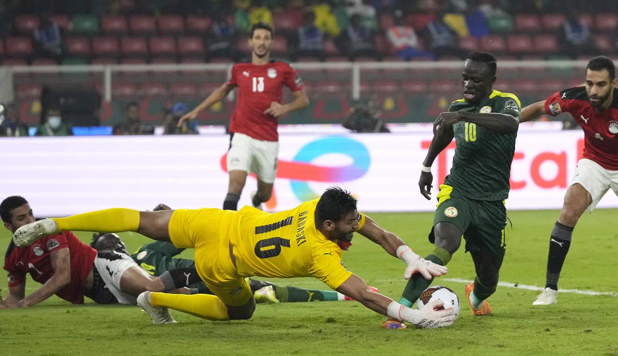 Kiper Mesir, Mohamed Abogabal (tengah) menangkap bola dari ancaman striker Senegal, Sadio Mane dalam laga final Piala Afrika 2021 di Stade d'Olembe, Yaounde, Kamerun (6/2/2022). (AP/Themba Hadebe)