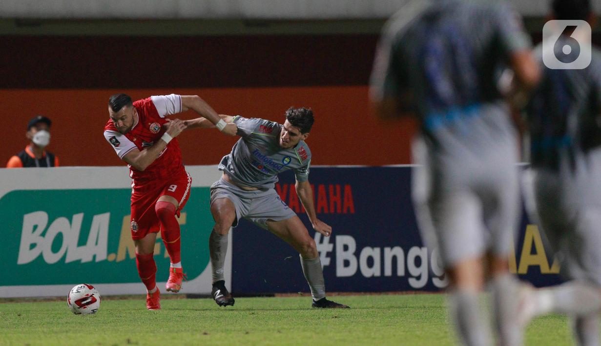 Striker Persija Jakarta, Marko Simic (kiri) berebut bola dengan bek Persib Bandung, Nick Kuipers, pada laga final Piala Menpora 2021 di Stadion Maguwoharjo, Sleman, Kamis (22/4/2021). Persija menang dengan skor 2-0. (Bola.com/M Iqbal Ichsan)