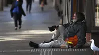 Seorang pria meminta uang di kawasan pusat bisnis Melbourne pada Rabu (2/9/2020). Australia memasuki resesi pertama mereka sejak 1991 setelah perekonomian menyusut 7,0 persen pada kuarter kedua saat negara itu berjuang menghadapi pandemi COVID-19. (William WEST / AFP)