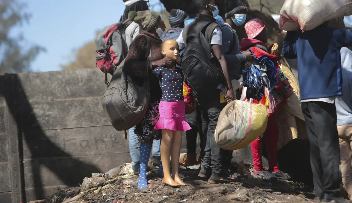 Pedagang Zimbabwe bersembunyi dari polisi setelah mereka diusir dari menjual barang dagangannya dari area yang tidak ditentukan karena pembatasan COVID-19 di Harare, Kamis (29/7/2021). (AP Photo/Tsvangirayi Mukwazhi)