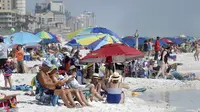 Para pengunjung berkumpul menikmati pantai di Destin, Florida, Amerika Serikat, Rabu (18/3/2020). Pantai Florida masih ramai dikunjungi pengunjung kendati virus corona COVID-19 telah menyebar ke seluruh Amerika Serikat. (Devon Ravine/Northwest Florida Daily News via AP)