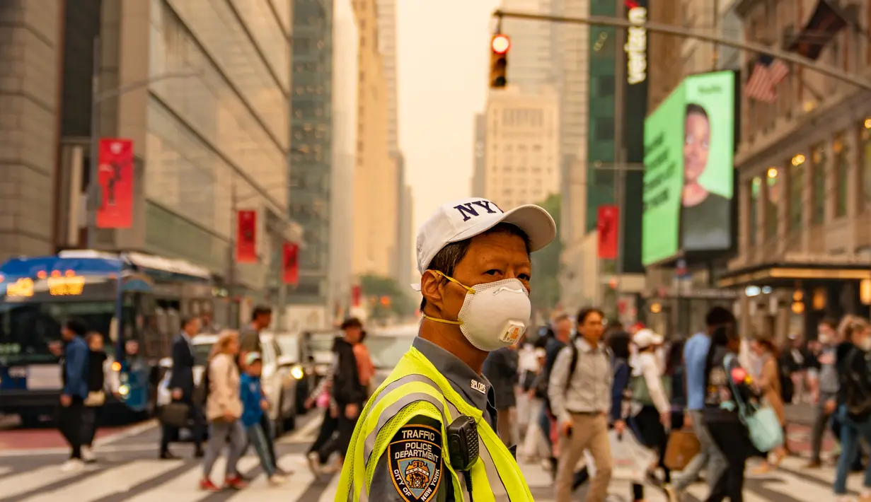 Pengunjung Times Square di New York tampak tidak terganggu oleh asap kebakaran hutan pekat yang menyelimuti area tersebut pada hari Rabu, 7 Juni.  (David Dee Delgado/Getty Images/AFP)