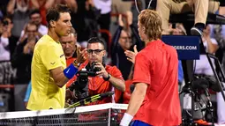 Petenis Spanyol, Rafael Nadal mengucapkan selamat kepada petenis Kanada, Denis Shapovalov seusai turnamen Piala Rogers di Montreal, Kamis (10/8). Nadal disingkirkan petenis 18 tahun itu dengan skor 6-3, 4-6, 6-7. (MINAS PANAGIOTAKIS/GETTY IMAGES/AFP)