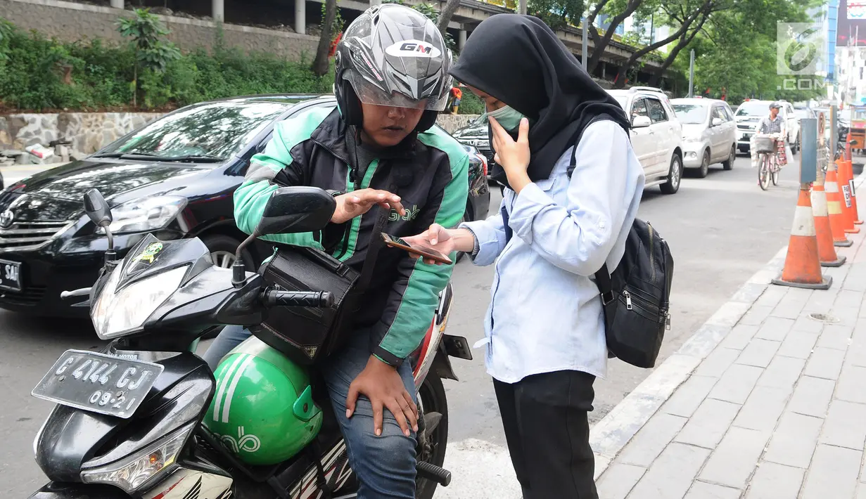 Pengemudi ojek online menerima penumpang di Jakarta, Selasa (19/3). Kementerian Perhubungan (Kemenhub) memastikan aturan ojek online sudah ditandatangani pada 11 Maret 2019. (Liputan6.com/Herman Zakharia)