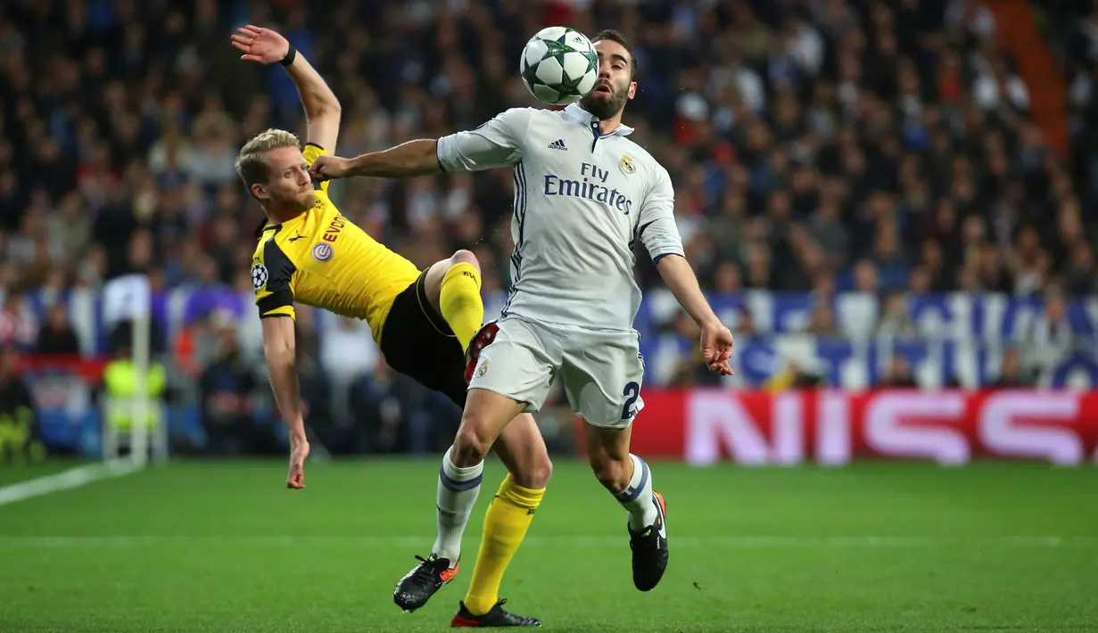 Bek Real Madrid, Daniel Carvajal (depan) berusaha mengontrol bola dari kawalan Penyerang Dortmund, Andre Schurrle di Grup F Liga Champions di Santiago Bernabeu, Madrid, (8/12). Real Madrid bermain imbang 2-2 dengan Dortmund. (REUTERS/Susana Vera)