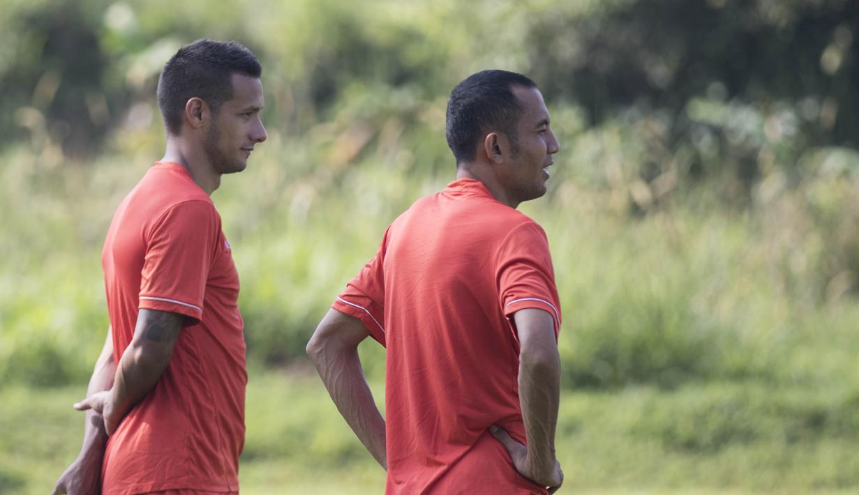 Pemain Persija, Raphael Maitimo, dan Muhammad Ilham, memperhatikan rekan-rekan berlatih jelang babak 8 besar Piala Jenderal Sudirman di Lapangan Sawangan, Depok, Jawa Barat, Senin (7/12/2015). (Bola.com/Vitalis Yogi Trisna) 