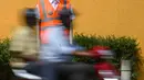 Pengendara melintasi manekin pria berseragam polisi lalu lintas di persimpangan jalan di Bangalore, India, Senin (16/12/2019). Polisi manekin itu diharapkan bisa mengelabui pengemudi yang akan mengiranya sebagai polisi asli sehingga mengurungkan niat melanggar lalu lintas. (Manjunath KIRAN / AFP)