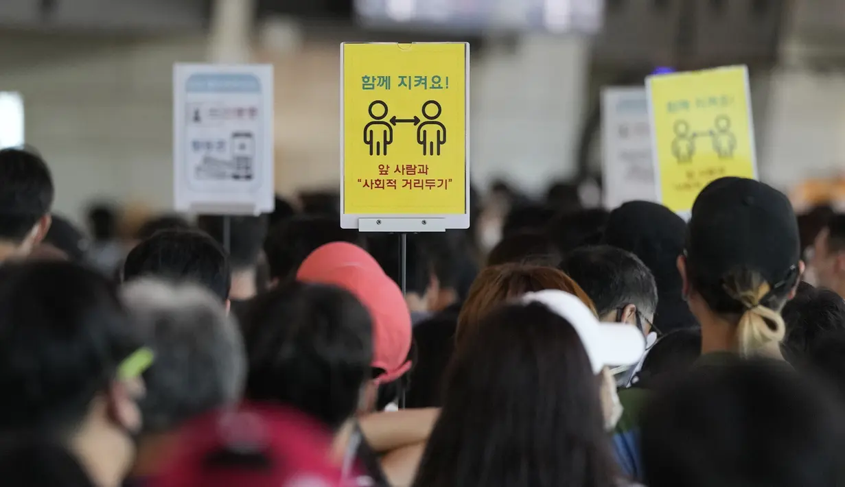 Tanda-tanda jarak sosial terlihat saat penumpang menunggu untuk naik pesawat menjelang liburan Chuseok mendatang, Hari Thanksgiving versi Korea di terminal penerbangan domestik bandara Gimpo di Seoul, Korea Selatan (18/9/2021). (AP Photo/Ahn Young-joon)
