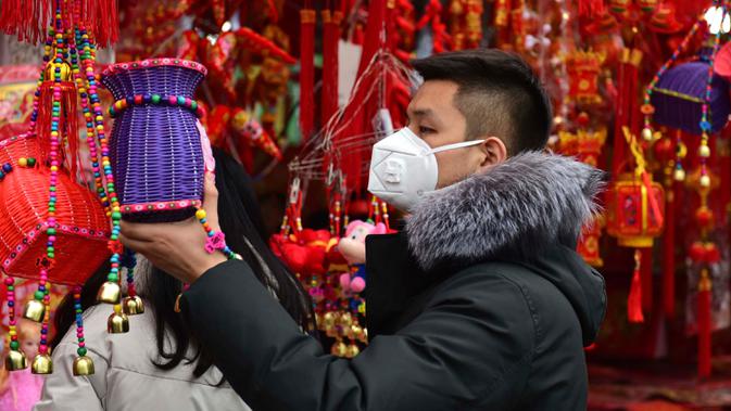 Seorang pria berbelanja dekorasi untuk perayaan Tahun Baru  Imlek di sebuah pasar di Provinsi Anhui, China, 23 Januari 2020. China menutup sebuah kota berpenduduk lebih dari 11 juta orang dalam upaya memerangi wabah virus corona, tindakan yang belum pernah terjadi sebelumnya.  (AP/Mark Schiefelbein)