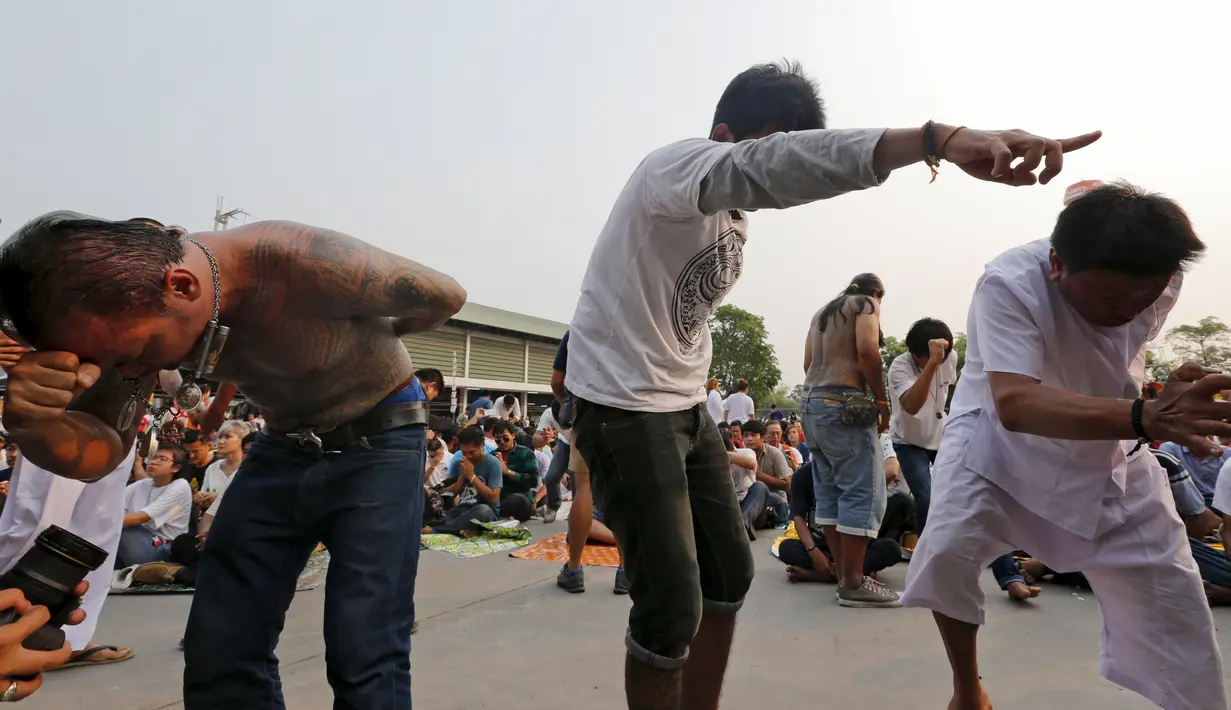 Sejumlah warga dalam keadaan kesurupan mengikuti Festival Tato Sihir di Wat Bang Phra, Bangkok, Thailand (19/3). Mereka percaya tato memiliki kekuatan mistis, menangkal nasib buruk dan melindungi mereka dari bahaya. (REUTERS/Chaiwat Subprasom)