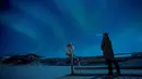 Seorang pria berdiri di dermaga untuk menonton Aurora Borealis atau Northern Lights di Kepulauan Lofoten, Bostad, Arktik, Norwegia, Sabtu (3/3). Aurora menampilkan banyak warna, tapi yang sering muncul adalah hijau muda dan pink. (Olivier MORIN/AFP)