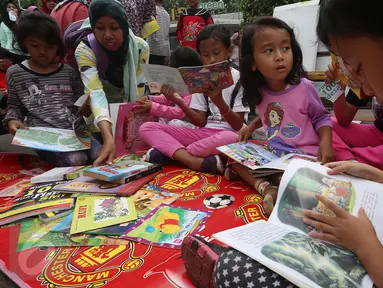 Sejumlah anak membaca buku di Kawasan Bundaran HI saat berlangsungnya Hari Bebas Kendaraan Bermotor atau Car Free Day (CFD), Jakarta, Minggu (2/4). Gerakan yang digagas oleh komunitas "Buku 100 Desa" . (Liputan6.com/Johan Tallo)