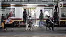 Penumpang Commuter Line menunggu kedatangan kereta di Stasiun Jatinegara, Jakarta, Rabu (16/12/2020). Dirjen Perkeretaapian Kemenhub mengubah level crossing (lintas bawah) menjadi overpass (lintas atas) demi meningkatkan keselamatan penumpang. (merdeka.com/Iqbal S. Nugroho)