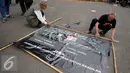 Aktivis Jaringan Solidaritas Korban memasang spanduk saat menggelar aksi Kamisan di depan Istana Merdeka, Jakarta, Kamis (29/12). Dalam aksi dipengujung tahun 2016 mereka menuntut pemerintah menyelesaikan berbagai kasus HAM. (Liputan6.com/Gempur M Surya)