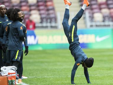 Aksi pemain Brasil, Dani Alves (kanan) saat berjalan dengan tangan pada sesi latihan di Stadion Olimpiyskiy Luzhniki, Moskva, Rusia, (22/3/2018). Brasil akan melawan Rusia pada laga uji coba 23 Maret. (AP/Pavel Golovkin)