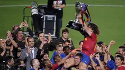 Pelatih Barcelona, Pep Guardiola menyaksikan selebrasi Carles Puyol dengan mengangkat trofi Liga Spanyol 2008/2009 setelah laga pekan terakhir menghadapi Osasuna di Camp Nou Stadium, Barcelona (16/5/2009). (AFP/Lluis Gene)